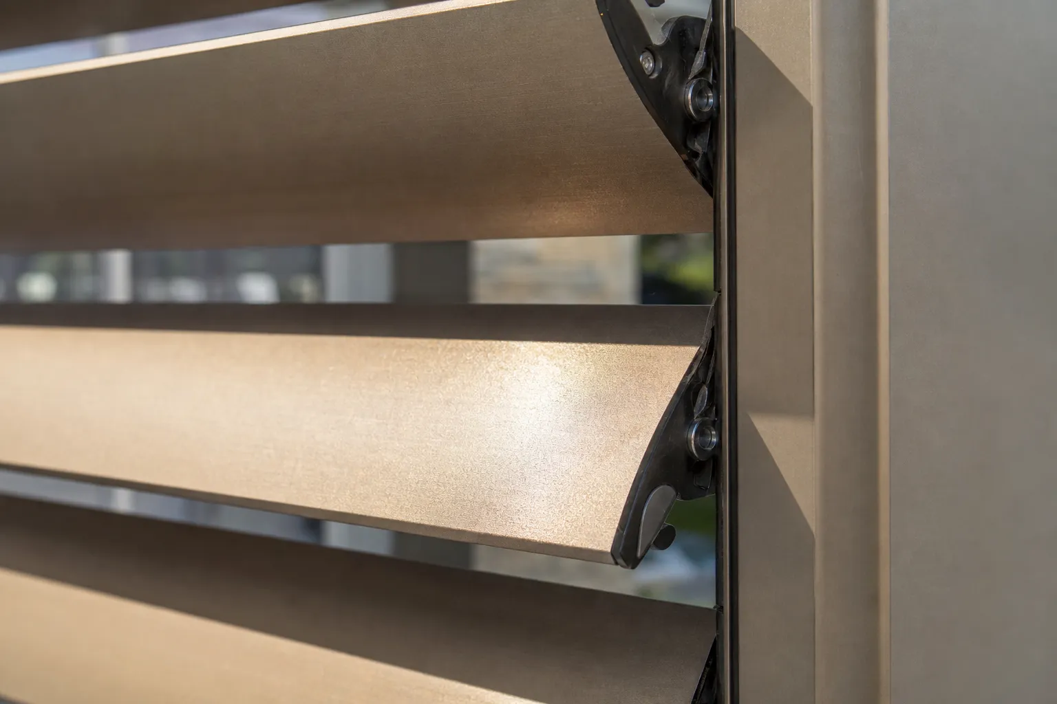 Gros plan sur les lames orientables en aluminium anodisé d’une pergola bioclimatique, finition brossée
